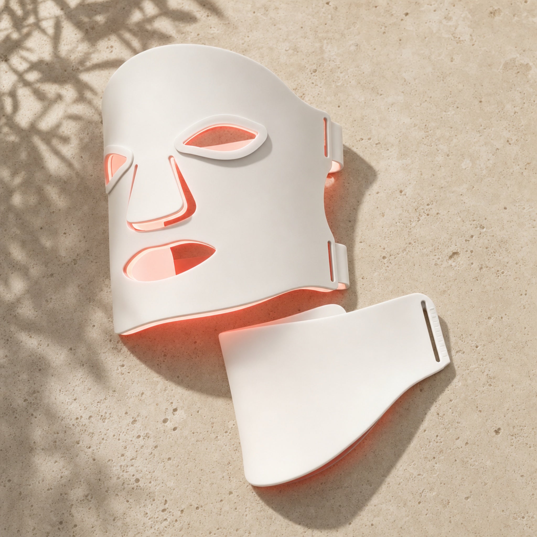 Redermis LED mask and neck panel laid flat on travertine stone [white]